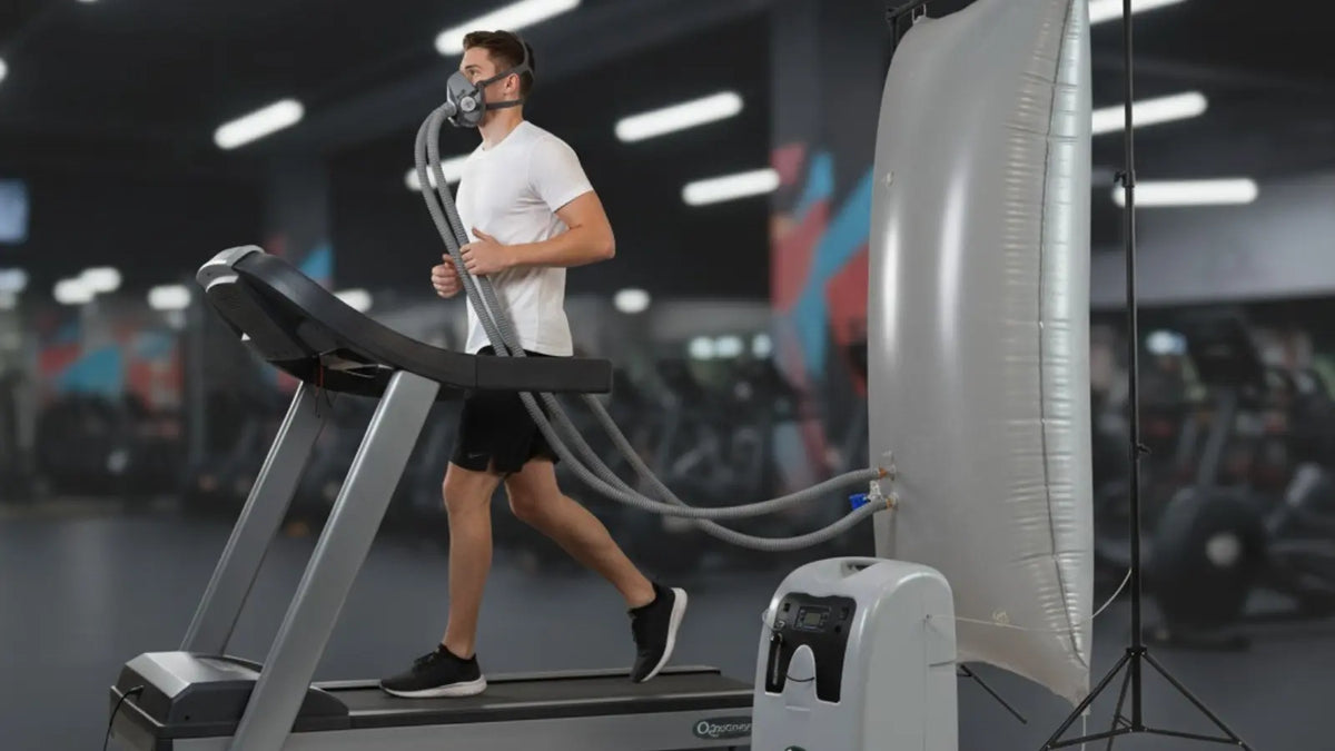 EWOT system setup with oxygen concentrator, reservoir bag and mask connected to a treadmill user