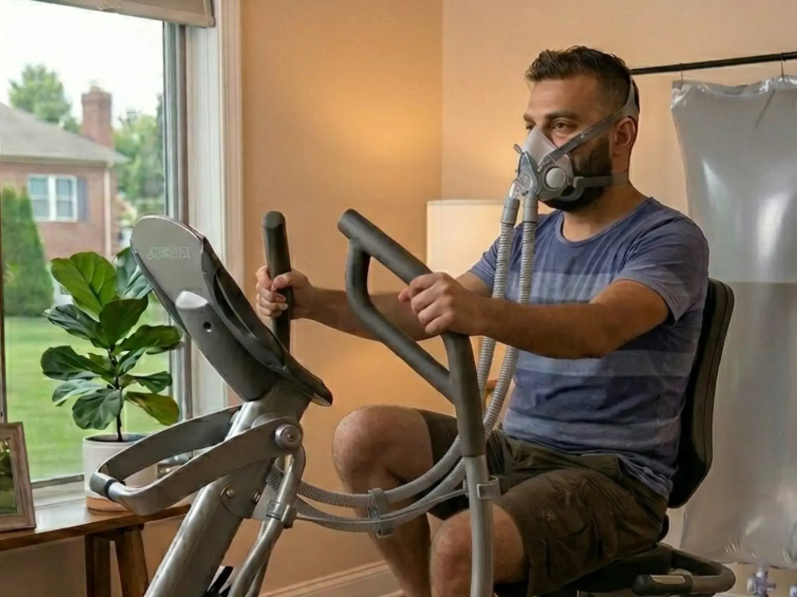 Man exercising on a stationary bike with an oxygen mask in a home setting