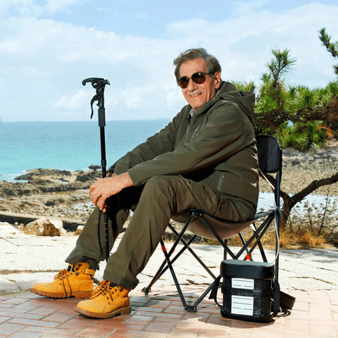 Man sitting on a chair by the ocean with 5 LPM Portable Oxygen Concentrator
