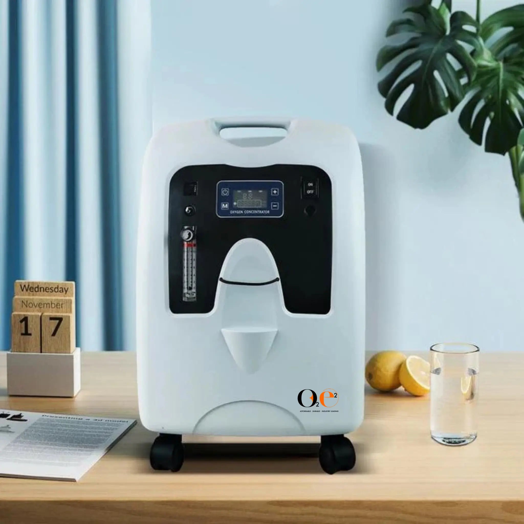 White and black stationary oxygen concentrator on a wooden table with a light blue wall and plant in the background.