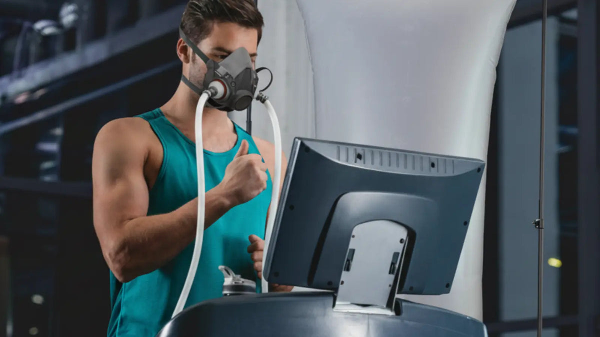 Man exercising on a treadmill while breathing oxygen through an EWOT mask